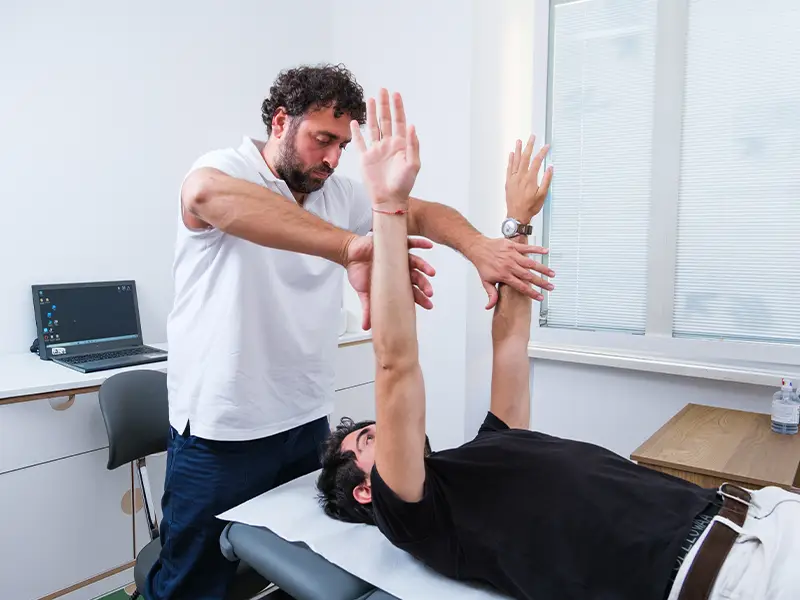 Dottore che pratica la Kinesiologia e approccio posturale ad un paziente