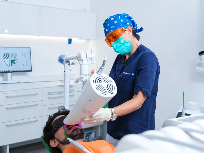 dottoressa esegue lo sbiancamento dentale ad un paziente